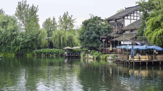 Mesas de té y edificios junto al río tranquilo
