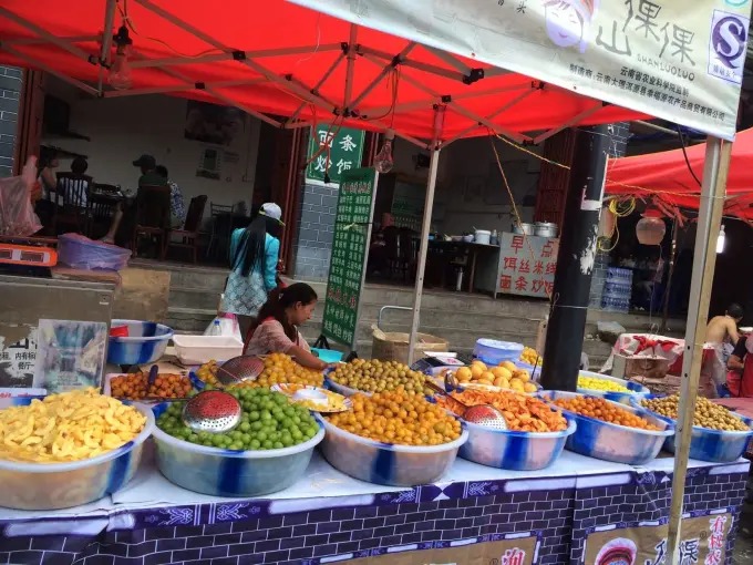 Tigelas de frutas em conserva em uma barraca sob cobertura vermelha