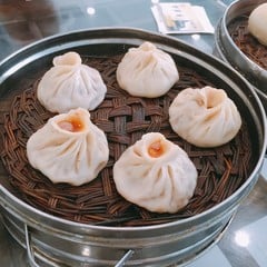 Pleated steamed buns in a bamboo basket