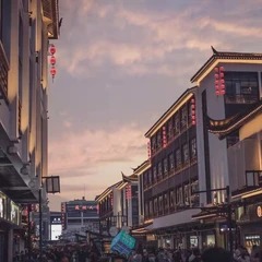 Holzfassaden einer belebten Straße unter dem Abendhimmel